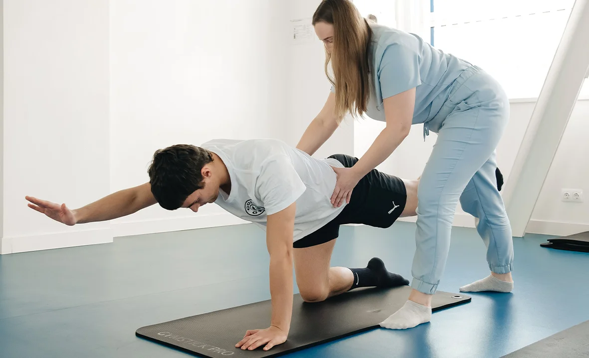 Eine Person in Blau erhält von einer anderen im Therapiezentrum Reform eine vorsichtige Nackendehnung.